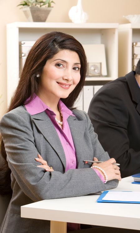 Imagen de latina de negocios con blusa morada, traje gris se muestra en la sección Pros y contras de vender anualidad.