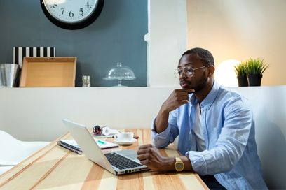 Black man with glasses using laptop shown on the Sell Annuity Home page.
