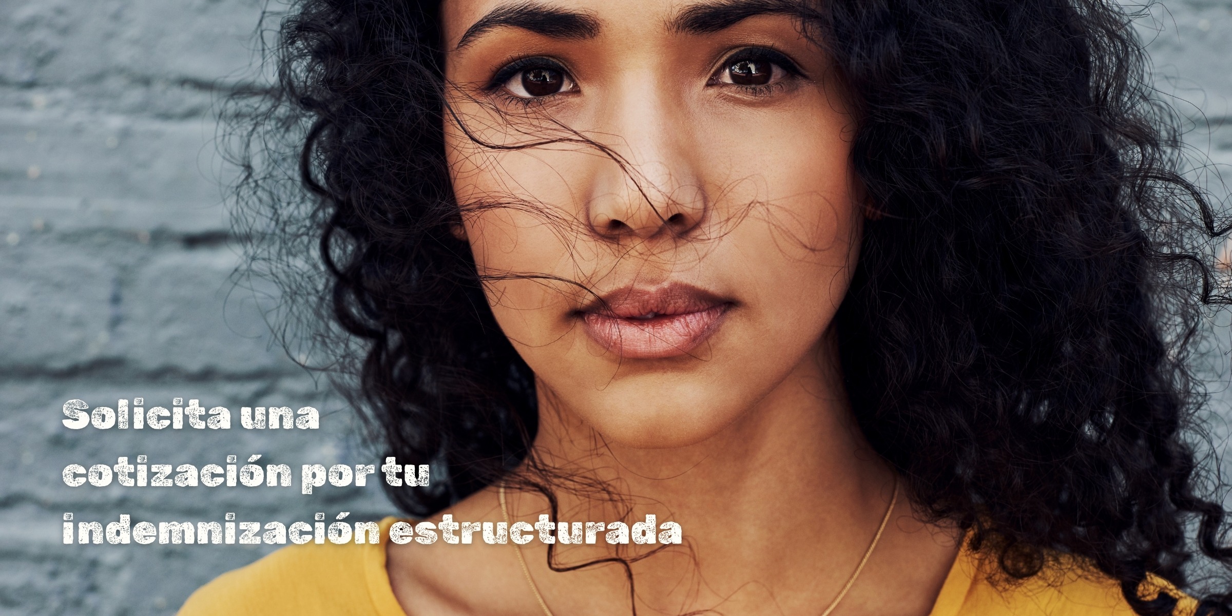Una latina frente a un muro de ladrillos grises con las palabras "Solicita una cotización por tu indemnización estructurada."